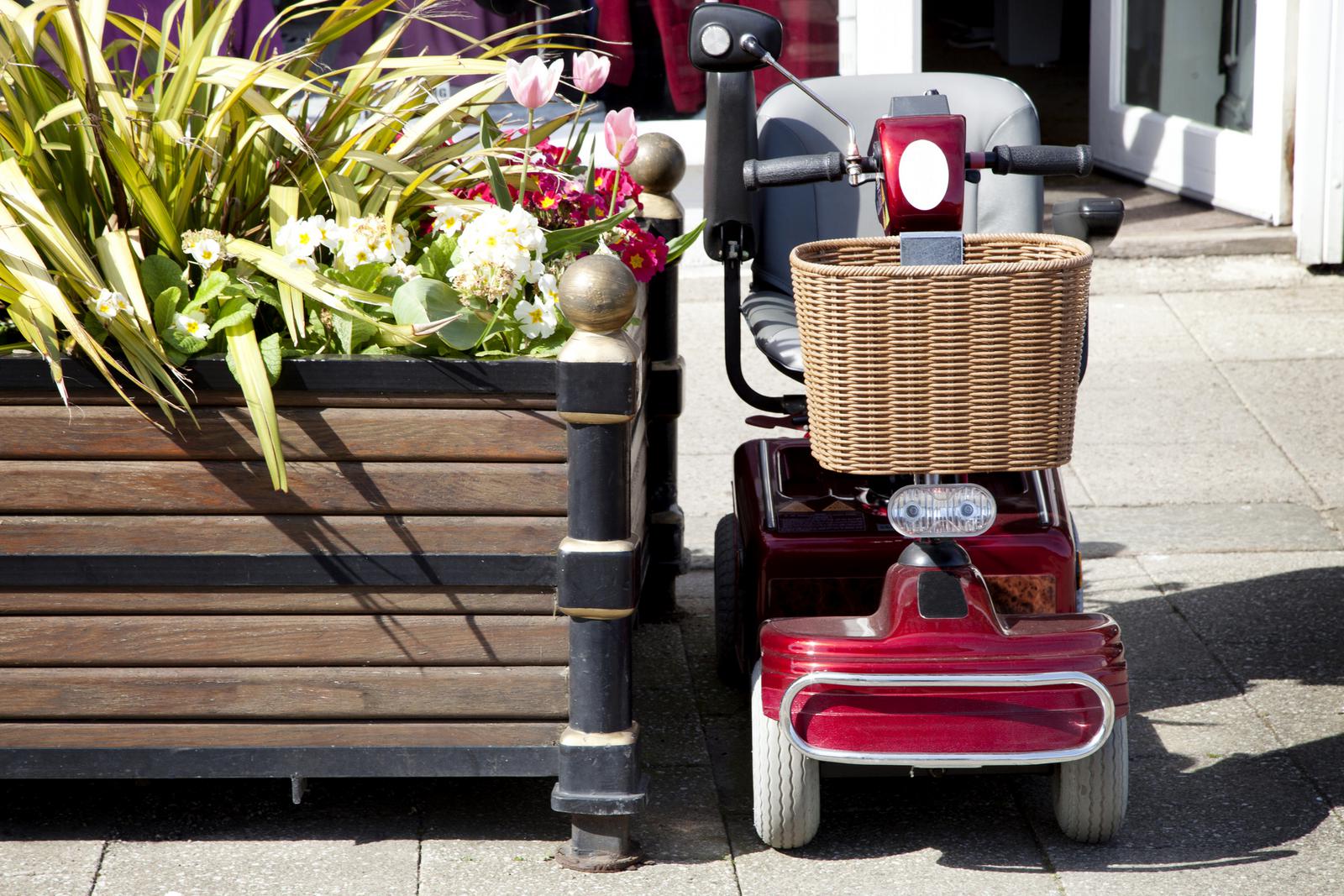 Mobility scooter posed next to planter on street